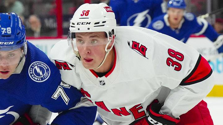 Sep 26, 2023; Raleigh, North Carolina, USA; Carolina Hurricanes right wing Noel Gunler (36) and Tampa Bay Lightning defensemen Emil Lillieberg (78) skate after the loose puck during the first period at PNC Arena. Mandatory Credit: James Guillory-Imagn Images