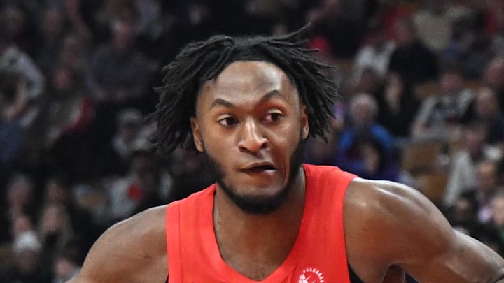 Toronto Raptors guard Immanuel Quickley dribbles past Chicago Bulls guard Anfernee Simons.