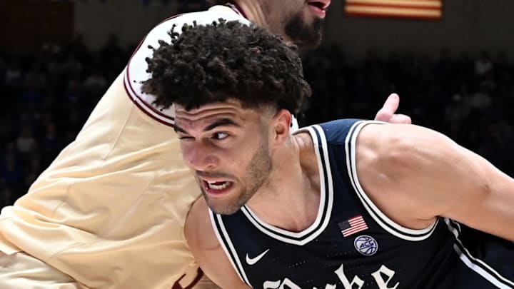 Feb 3, 2026; Durham, North Carolina, USA;  Duke Blue Devils forward Cameron Boozer (12) drives to the basket as Boston College Eagles forward Aiden Shaw (23) defends during the second half at Cameron Indoor Stadium. Mandatory Credit: Rob Kinnan-Imagn Images