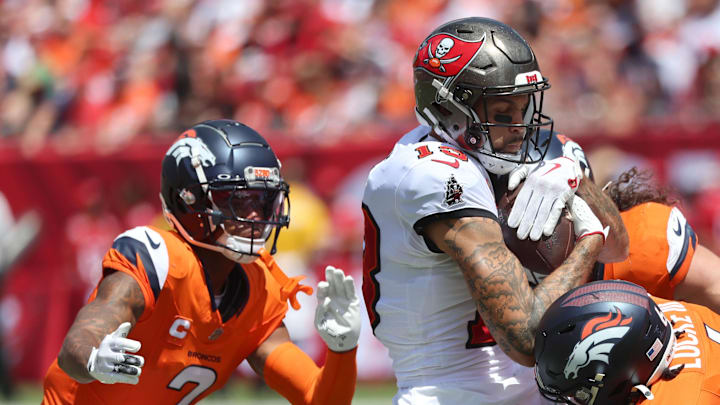 Sep 22, 2024; Tampa, Florida, USA; Denver Broncos safety P.J. Locke (6), cornerback Pat Surtain II (2) and linebacker Alex Singleton (49) tackle Tampa Bay Buccaneers wide receiver Mike Evans (13) after a reception during the first half at Raymond James Stadium. Mandatory Credit: Kim Klement Neitzel-Imagn Images
