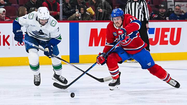 Jan 12, 2026; Montreal, Quebec, CAN; Montreal Canadiens right wing Brendan Gallagher (11) plays the puck against Vancouver Canucks defenseman Pierre-Olivier Joseph (7) during the second period at Bell Centre. Mandatory Credit: David Kirouac-Imagn Images