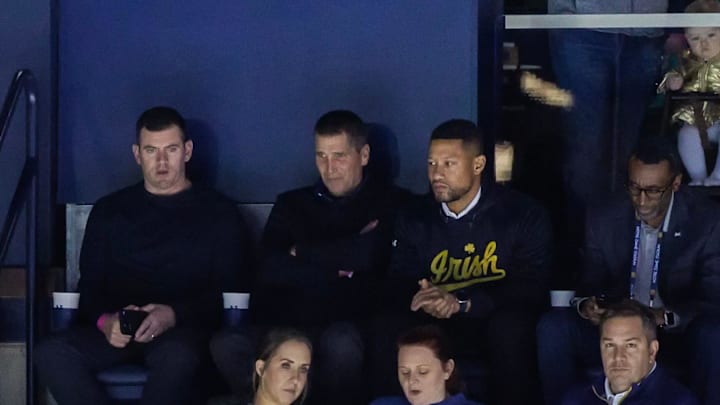 Notre Dame offensive coordinator candidate Andy Ludwig, second from left (top row), takes in a Notre Dame hockey game Friday, Feb. 10 at the Compton Family Ice Arena in South Bend. Seated next to him is Irish tight ends coach Gerad Parker (left) and ND head football coach Marcus Freeman (right). Ludwig is currently the OC at Utah