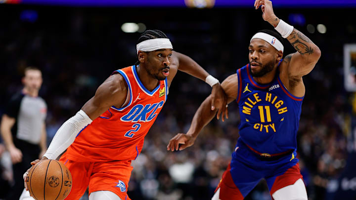 Feb 1, 2026; Denver, Colorado, USA; Oklahoma City Thunder guard Shai Gilgeous-Alexander (2) controls the ball as Denver Nuggets guard Bruce Brown (11) guards in the second quarter at Ball Arena.