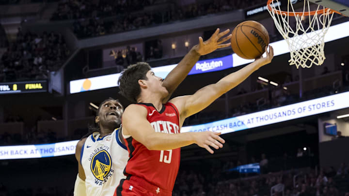 Dec 5, 2024; San Francisco, California, USA;  Houston Rockets guard Reed Sheppard (15) lays up the ball as Golden State Warriors forward Kevon Looney (5) defends during the fourth quarter at Chase Center. Mandatory Credit: John Hefti-Imagn Images