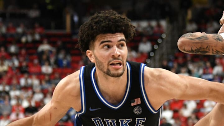 Mar 2, 2026; Raleigh, North Carolina, USA;  Duke Blue Devils forward Cameron Boozer (12) drives the ball around NC State Wolfpack forward Darrion Williams (1) during the first half at Lenovo Center. Mandatory Credit: Zachary Taft-Imagn Images