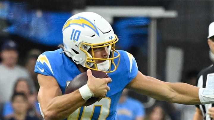 Los Angeles Chargers quarterback Justin Herbert stiff arm Tennessee Titans linebacker Jack Gibbens. Los Angeles Chargers quarterback Justin Herbert stiff arm Tennessee Titans linebacker Jack Gibbens.