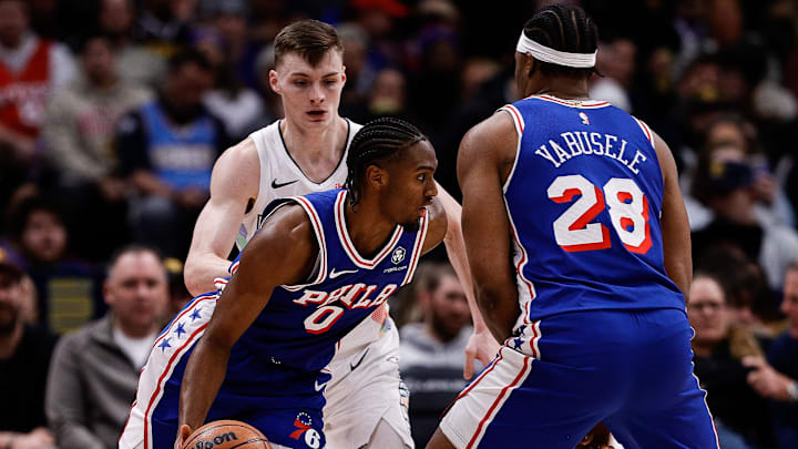 Jan 21, 2025; Denver, Colorado, USA; Philadelphia 76ers guard Tyrese Maxey (0) controls the ball as forward Guerschon Yabusele (28) screens against Denver Nuggets guard Christian Braun (0) as referee Andy Nagy (83) looks on in the first quarter at Ball Arena. Mandatory Credit: Isaiah J. Downing-Imagn Images