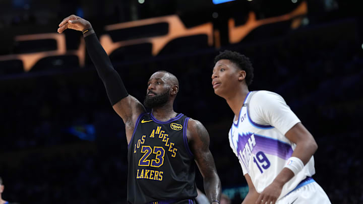 Nov 18, 2025; Los Angeles, California, USA; Los Angeles Lakers forward LeBron James (23) follows through on a three-point shot against Utah Jazz guard Ace Bailey (19) in the second quarter at Crypto.com Arena. Mandatory Credit: Kirby Lee-Imagn Images