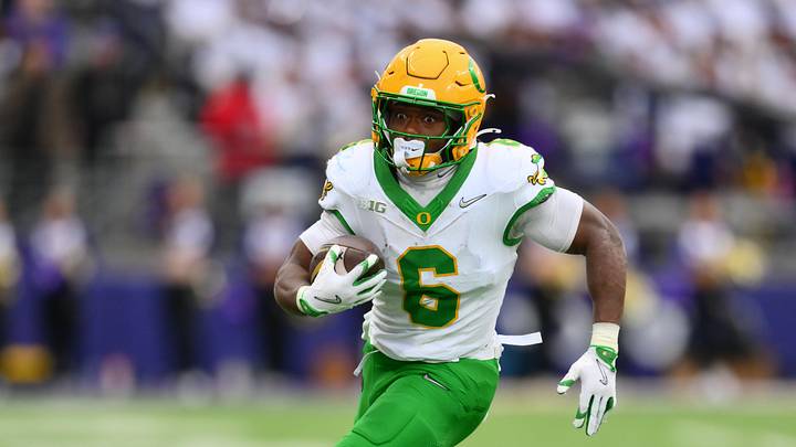 Nov 29, 2025; Seattle, Washington, USA; Oregon Ducks running back Noah Whittington (6) carries the ball against the Washington Huskies during the first half at Husky Stadium. Mandatory Credit: Steven Bisig-Imagn Images