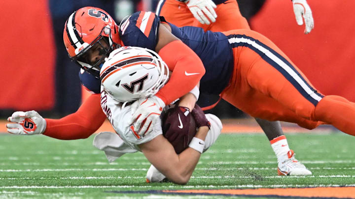 Nov 2, 2024; Syracuse, New York, USA; Syracuse Orange defensive lineman Fadil Diggs (10) makes a tackle on Virginia Tech Hokies wide receiver Stephen Gosnell (12) in the first quarter at JMA Wireless Dome. Mandatory Credit: Mark Konezny-Imagn Images