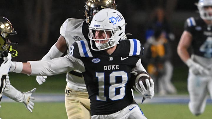 Nov 29, 2025; Durham, North Carolina, USA; Duke Blue Devils wide receiver Cooper Barkate (18) runs the ball against Wake Forest Demon Deacons defensive back Lardarius Webb Jr. (20) during the fourth quarter at Wallace Wade Stadium. Mandatory Credit: Zachary Taft-Imagn Images