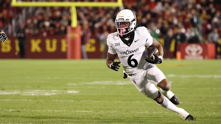 Nov 16, 2024; Ames, Iowa, USA; Cincinnati Bearcats running back Evan Pryor (6) runs away from Iowa State Cyclones  Carson Robbins (23) in the first half at Jack Trice Stadium. Mandatory Credit: Reese Strickland-Imagn Images