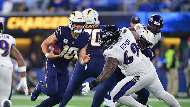 Nov 25, 2024; Inglewood, California, USA; Los Angeles Chargers quarterback Justin Herbert (10) runs the ball against Baltimore Ravens defensive tackle Josh Tupou (69) during the second half at SoFi Stadium. Mandatory Credit: Gary A. Vasquez-Imagn Images