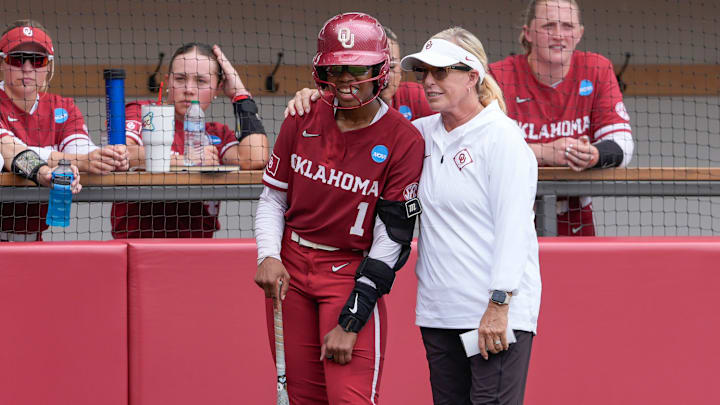 Oklahoma coach Patty Gasso talks with Oklahoma first baseman Cydney Sanders 