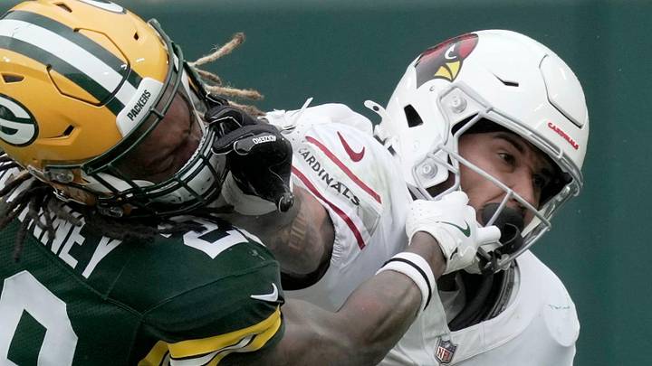 Green Bay Packers safety Xavier McKinney get a hand to the face while trying to tackle Cardinals running back James Conner.