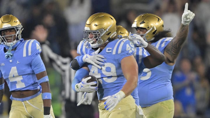 Nov 8, 2024; Pasadena, California, USA;   UCLA Bruins linebacker Carson Schwesinger (49) and teammates celebrate after an interception in the second half against the Iowa Hawkeyes at the Rose Bowl. Mandatory Credit: Jayne Kamin-Oncea-Imagn Images