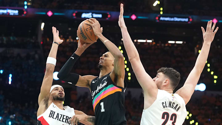 Apr 19, 2026; San Antonio, Texas, USA; San Antonio Spurs forward Victor Wembanyama (1) drives to the basket between Portland Trail Blazers forward Toumani Camara (33) and center Donovan Clingan (23) during the first half of game one of the first round of the 2026 NBA Playoffs at Frost Bank Center. Mandatory Credit: Scott Wachter-Imagn Images