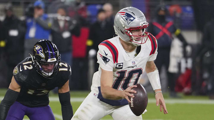 Dec 21, 2025; Baltimore, Maryland, USA;  New England Patriots quarterback Drake Maye (10) scrambles against Baltimore Ravens safety Alohi Gilman (12) during the second half of the game at M&T Bank Stadium. Mandatory Credit: Mitch Stringer-Imagn Images