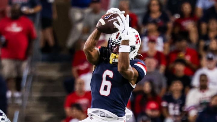Sep 12, 2025; Tucson, Arizona, USA; Arizona Wildcats wide receiver Javin Whatley (6) catches the ball while Kansas State Wildcats defensive end Chiddi Obiazor (8) defends during the second quarter of the game at Arizona Stadium. Mandatory Credit: Aryanna Frank-Imagn Images