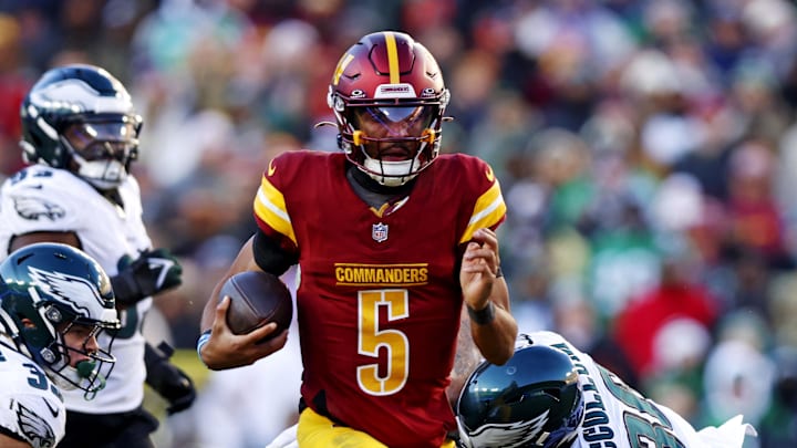 Dec 22, 2024; Landover, Maryland, USA; Washington Commanders quarterback Jayden Daniels (5) runs the ball against Philadelphia Eagles safety Tristin McCollum (36) during the third quarter at Northwest Stadium. Mandatory Credit: Peter Casey-Imagn Images