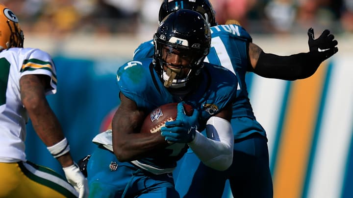 Jacksonville Jaguars running back Tank Bigsby (4) rushes for yards against Green Bay Packers safety Xavier McKinney (29) during the fourth quarter of an NFL football matchup Sunday, Oct. 27, 2024 at EverBank Stadium in Jacksonville, Fla. The Packers edged the Jaguars 30-27 on a last-second field goal. [Corey Perrine/Florida Times-Union]