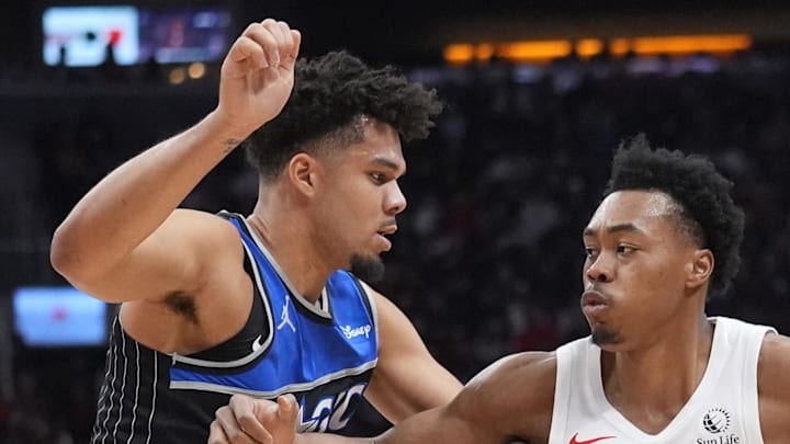 Toronto Raptors guard Scottie Barnes blocks tries to get around Orlando Magic forward Noah Penda.