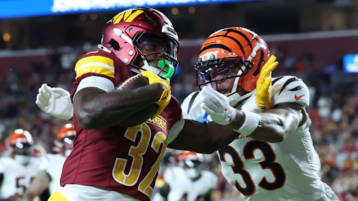 Aug 18, 2025; Landover, Maryland, USA; Washington Commanders running back Jacory Croskey-Merritt (32) scores a touchdown as Cincinnati Bengals safety Daijahn Anthony (33) defends during the first half at Northwest Stadium. Mandatory Credit: Amber Searls-Imagn Images