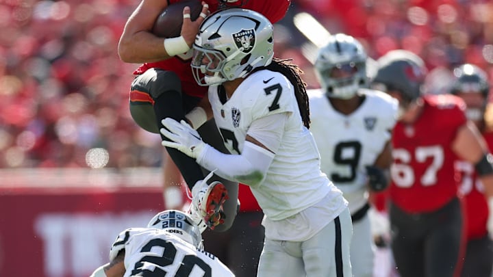 Dec 8, 2024; Tampa, Florida, USA; Tampa Bay Buccaneers tight end Cade Otton (88) is stopped by Las Vegas Raiders safety Tre'von Moehrig (7) in the first quarter at Raymond James Stadium. Mandatory Credit: Nathan Ray Seebeck-Imagn Images