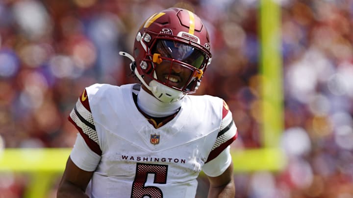 Sep 7, 2025; Landover, Maryland, USA; Washington Commanders quarterback Jayden Daniels (5) runs the ball against New York Giants linebacker Brian Burns (0) during the second quarter at Northwest Stadium. Mandatory Credit: Peter Casey-Imagn Images