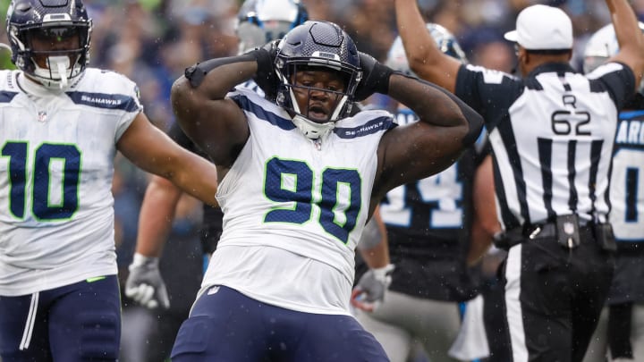 Sep 24, 2023; Seattle, Washington, USA; Seattle Seahawks defensive tackle Jarran Reed (90) celebrates after forcing a turnover on downs by sacking Carolina Panthers quarterback Andy Dalton (14, background) during the fourth quarter at Lumen Field. Mandatory Credit: Joe Nicholson-USA TODAY Sports
