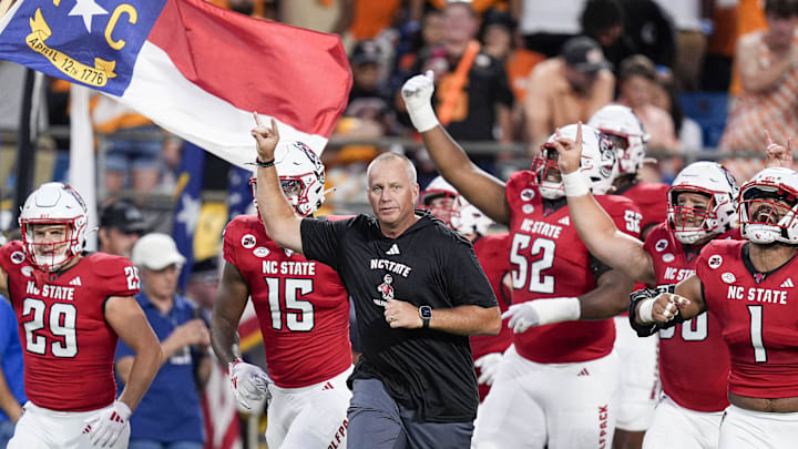 Sep 7, 2024; Charlotte, North Carolina, USA; North Carolina State Wolfpack head coach Dave Doeren leads his team onto the field against the Tennessee Volunteers during the first quarter at the Dukes Mayo Classic at Bank of America Stadium. Mandatory Credit: Jim Dedmon-Imagn Images