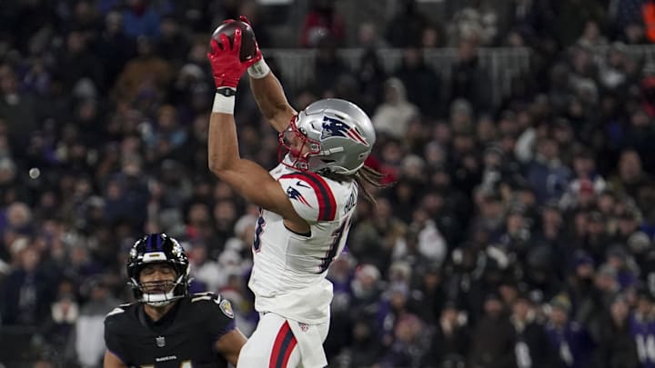 Dec 21, 2025; Baltimore, Maryland, USA;  New England Patriots wide receiver Mack Hollins (13) makes a catch against Baltimore Ravens safety Kyle Hamilton (14) during the first half of the game at M&T Bank Stadium. Mandatory Credit: James Lang-Imagn Images