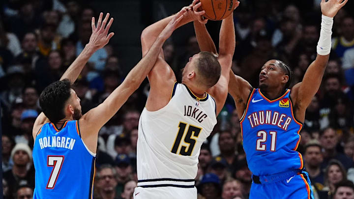 Oct 24, 2024; Denver, Colorado, USA; Oklahoma City Thunder forward Chet Holmgren (7) and guard Aaron Wiggins (21) and guard Ajay Mitchell (25) defend Denver Nuggets center Nikola Jokic (15) in the second quarter at Ball Arena. Mandatory Credit: Ron Chenoy-Imagn Images