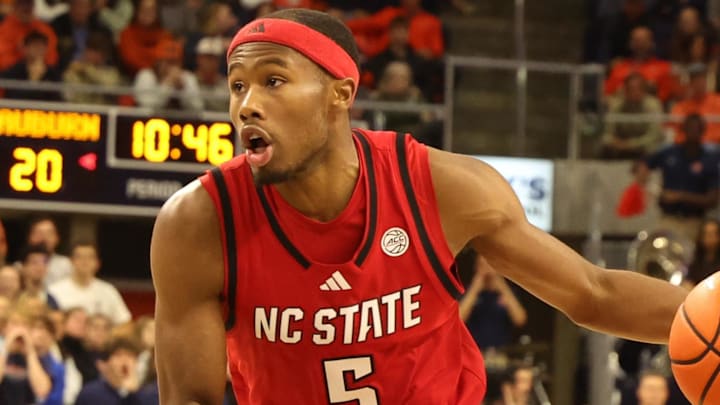 Dec 3, 2025; Auburn, Alabama, USA;  NC State Wolfpack guard Tre Holloman (5) runs a play as Auburn Tigers guard Kaden Magwood (5) defends during the first half at Neville Arena. Mandatory Credit: John Reed-Imagn Images