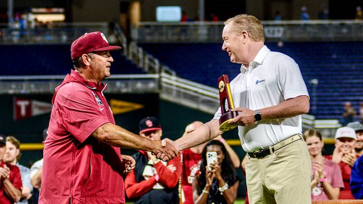 Oklahoma coach Skip Johnson walks across the stage at Charles Schwab Field after winning the national championship.
