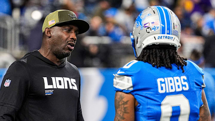 Detroit Lions assistant head coach and wide receivers coach Scottie Montgomery talks to running back Jahmyr Gibbs (0) 