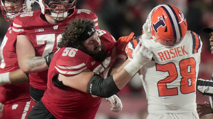 Wisconsin offensive lineman Joe Brunner (56) loses his helmet while blocking Illinois linebacker Dylan Rosiek (28) during the first quarter of their game Saturday, November 22, 2025 at Camp Randall Stadium in Madison, Wisconsin.