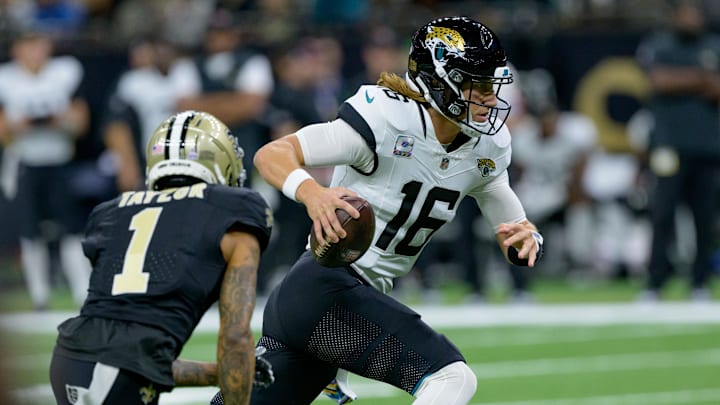 Oct 19, 2023; New Orleans, Louisiana, USA; Jacksonville Jaguars quarterback Trevor Lawrence (16) runs against New Orleans Saints cornerback Alontae Taylor (1) during the first quarter at the Caesars Superdome. Mandatory Credit: Matthew Hinton-Imagn Images