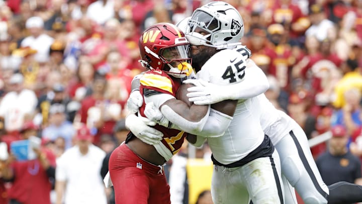 Sep 21, 2025; Landover, Maryland, USA; Washington Commanders defensive back Car'Lin Vigers (22) and Las Vegas Raiders linebacker Devin White (45) collide for the ball during the first half at Northwest Stadium. Mandatory Credit: Amber Searls-Imagn Images