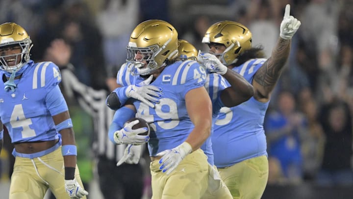 Nov 8, 2024; Pasadena, California, USA;   UCLA Bruins linebacker Carson Schwesinger (49) and teammates celebrate after an interception in the second half against the Iowa Hawkeyes at the Rose Bowl. Mandatory Credit: Jayne Kamin-Oncea-Imagn Images