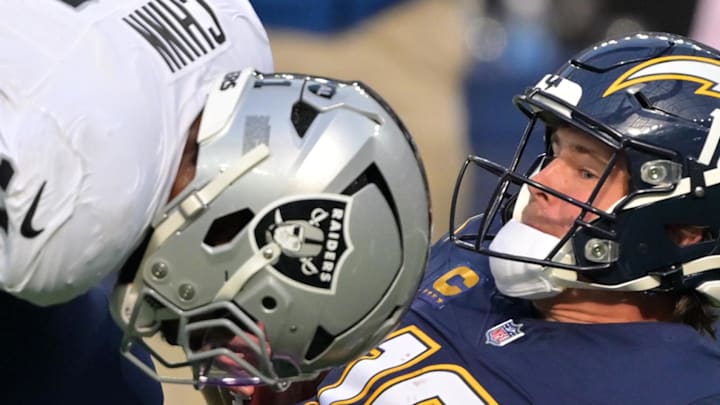 Nov 30, 2025; Inglewood, California, USA; Las Vegas Raiders safety Jeremy Chinn (11) tackles Los Angeles Chargers quarterback Justin Herbert (10) during the first half at SoFi Stadium. Mandatory Credit: Jayne Kamin-Oncea-Imagn Images