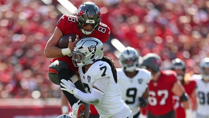 Dec 8, 2024; Tampa, Florida, USA; Tampa Bay Buccaneers tight end Cade Otton (88) is stopped by Las Vegas Raiders safety Tre'von Moehrig (7) in the first quarter at Raymond James Stadium. Mandatory Credit: Nathan Ray Seebeck-Imagn Images
