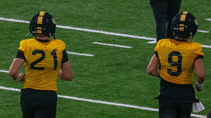 Aug 18, 2025; Columbia, MO, USA; Missouri Tigers quarterbacks Sam Horn (21) and Beau Pribula (9) jog to a drill at a fall camp practice at Stephens In