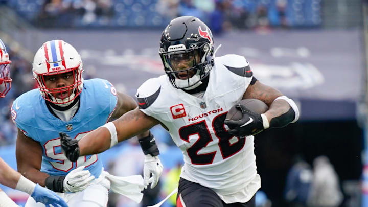 Houston Texans running back Joe Mixon (28) runs past Tennessee Titans linebacker Luke Gifford (57) during the first quarter at Nissan Stadium in Nashville, Tenn., Sunday, Jan. 5, 2025. Houston Texans running back Joe Mixon (28) runs past Tennessee Titans linebacker Luke Gifford (57) during the first quarter at Nissan Stadium in Nashville, Tenn., Sunday, Jan. 5, 2025.