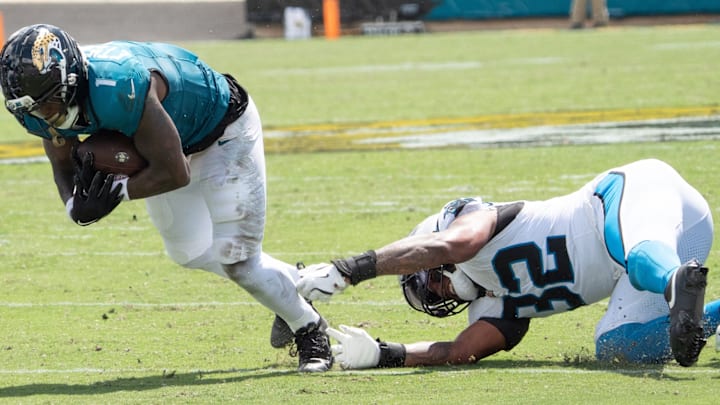 Jacksonville Jaguars running back Travis Etienne Jr. (1) dives forward and eludes a tackle by Carolina Panthers linebacker Trevin Wallace (32) during the second quarter of an NFL football game between the Carolina Panthers at Jacksonville Jaguars at EverBank Stadium Sunday September 7, 2025. Jacksonville Jaguars running back Travis Etienne Jr. (1) dives forward and eludes a tackle by Carolina Panthers linebacker Trevin Wallace (32) during the second quarter of an NFL football game between the Carolina Panthers at Jacksonville Jaguars at EverBank Stadium Sunday September 7, 2025.