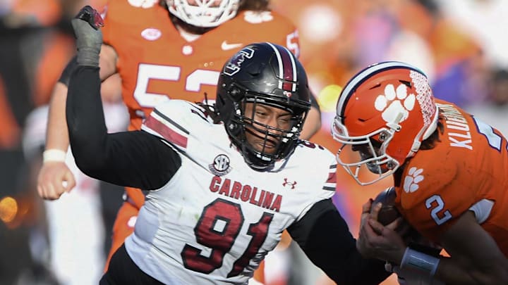 Nov 30, 2024; Clemson, South Carolina, USA; Clemson quarterback Cade Klubnik (2) is tackled by South Carolina defensive tackle Tonka Hemingway (91) and South Carolina linebacker Demetrius Knight Jr (17) during the fourth quarter at Memorial Stadium. Mandatory Credit: Ken Ruinard-Imagn Images