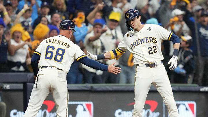 Oct 23, 2026; Milwaukee, Wisconsin, USA;  Milwaukee Brewers designated hitter Christian Yelich (22) celebrates with third base coach Matt Erickson (68) after hitting an RBI triple against the Tampa Bay Rays during the first inning in game one of the 2026 World Series at American Family Field.  Mandatory Credit: Michael McLoone-Imagn Images