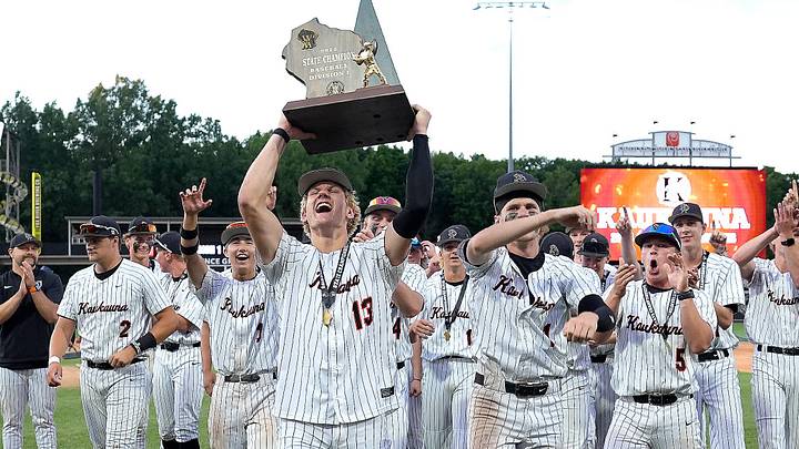 Kaukauna's Paxton Schuh (13) lifts the championship trophy following a victory over Madison Memorial  in the WIAA Division 1 state title game on Thursday, June 18, 2026.