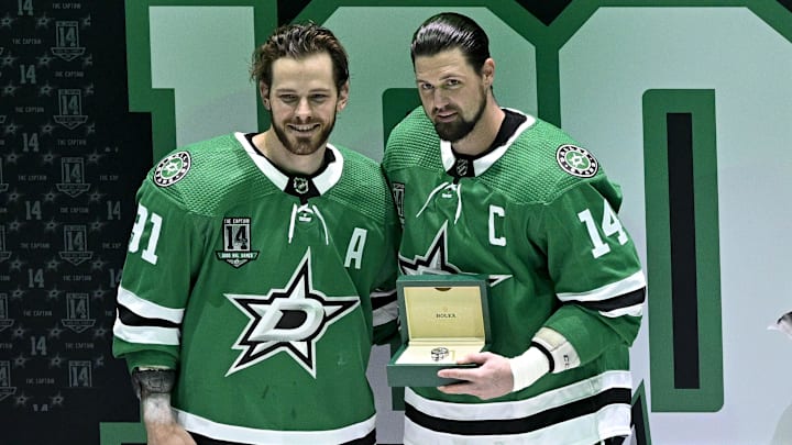 Mar 4, 2023; Dallas, Texas, USA; Dallas Stars center Tyler Seguin (91) presents left wing Jamie Benn (14) with a silver watch during a ceremony in recognition of Benn playing in 1000 career NHL games before the start of the game between the Dallas Stars and the Colorado Avalanche at the American Airlines Center. Mandatory Credit: Jerome Miron-Imagn Images