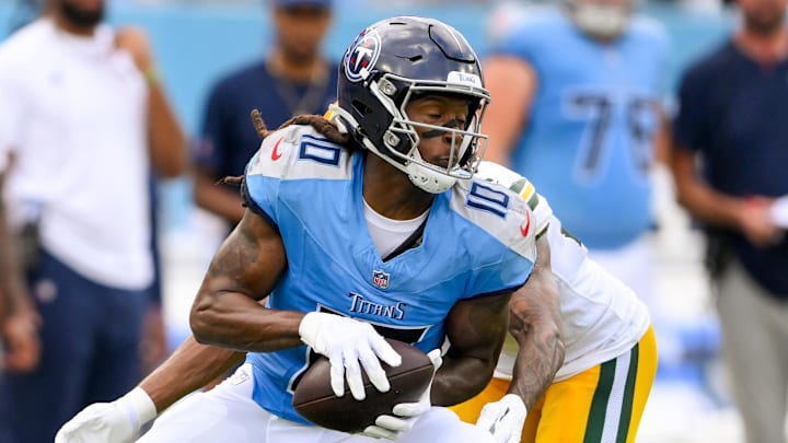 Sep 22, 2024; Nashville, Tennessee, USA;  Tennessee Titans wide receiver DeAndre Hopkins (10) makes a catch as Green Bay Packers cornerback Eric Stokes (21) converses during the first half at Nissan Stadium. Mandatory Credit: Steve Roberts-Imagn Images